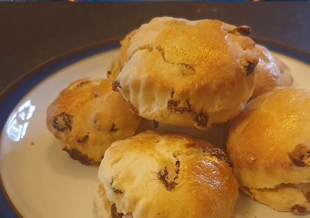 Fruit scones, glazed and risen, on a white plate