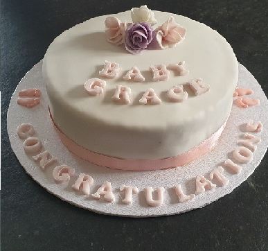 An ivory christening cake lettered Baby Grace