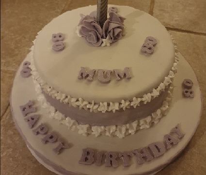 A lilac two-tier eightieth birthday cake