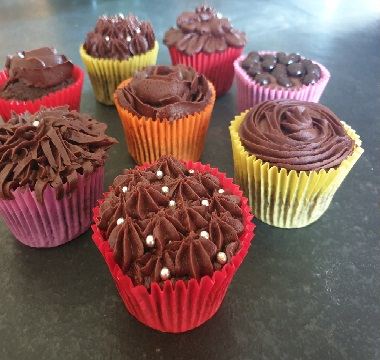 Chocolate cup cakes in bright paper cases, piped with chocolate buttercream