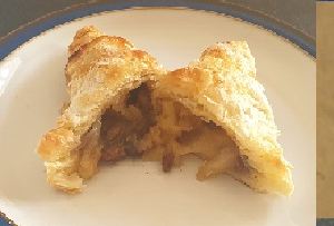An apple turnover broken open to show the filling